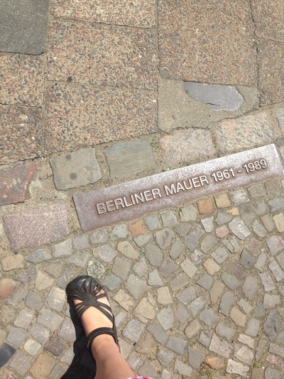 Sign marking the Berlin wall on the cobblestone reads: Berliner Mauer 1961-1989