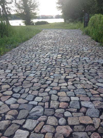 A cobble stone road meets the grass