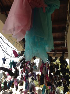 Dozens of sandals hang from the ceiling of the shop